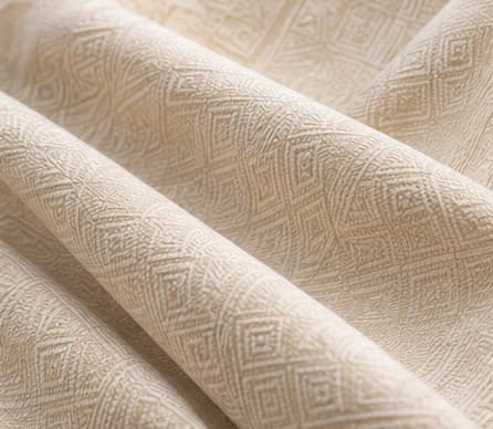 Warm cream woven fabric folded to reveal its texture and pattern